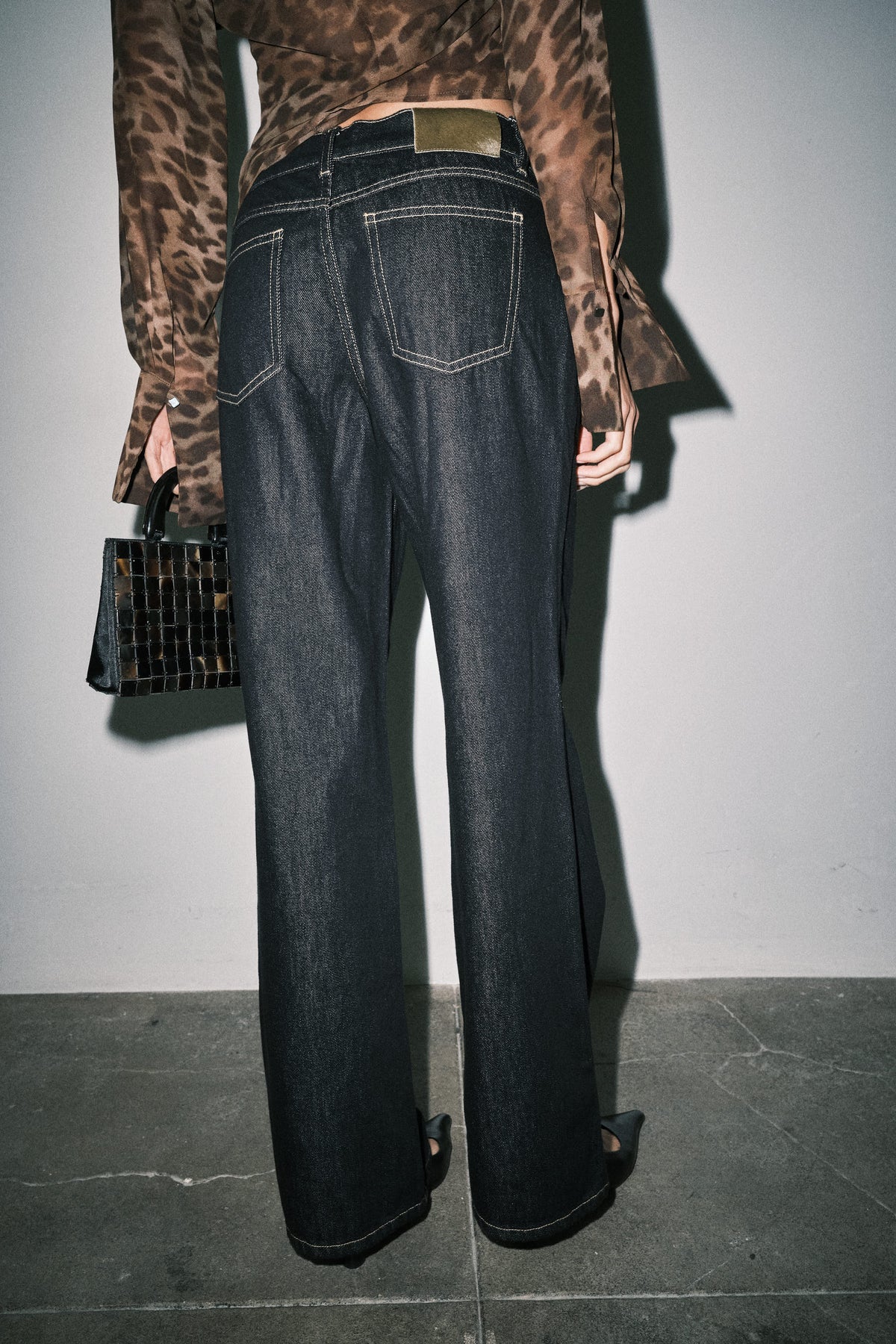 Close-up of dark wash wide leg jeans showing back pockets, waistband and contrast stitching