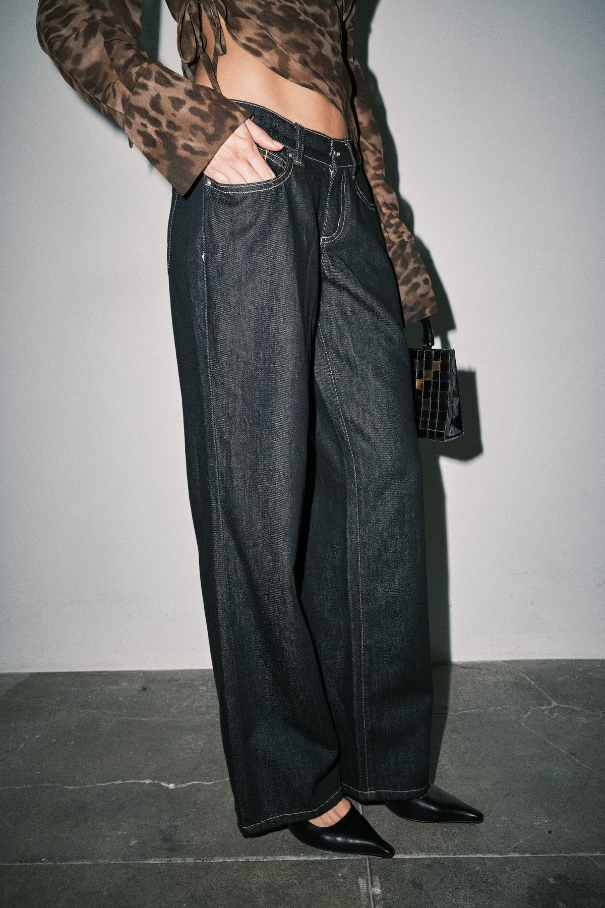 Close-up side detail of women's dark wash wide leg denim showing fabric and contrast stitching