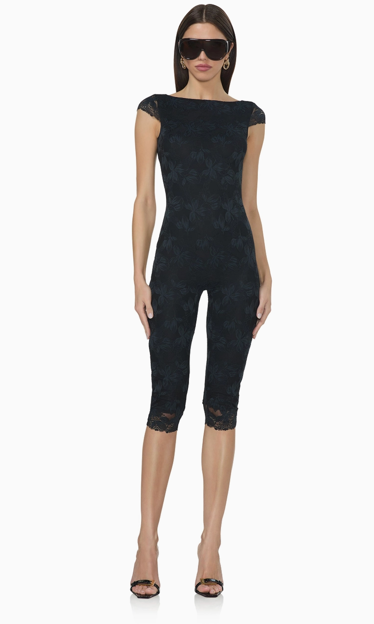 Front view of black floral lace capri catsuit featuring a fitted silhouette, boat neckline, delicate cap sleeves, and cropped lace-trimmed legs.