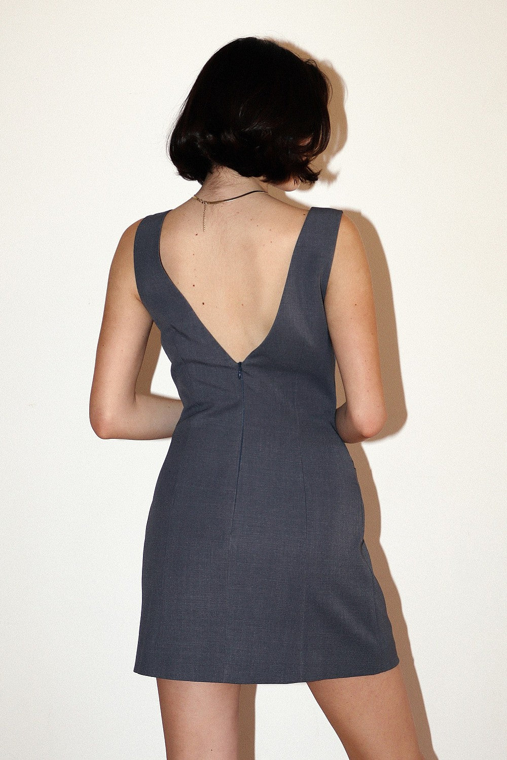 Back view of women's charcoal gray mini dress highlighting the fitted silhouette and short, straight hemline.