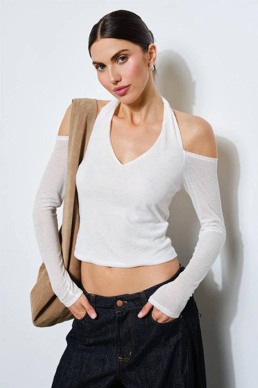 Front view of a white cropped halter top with a V-shaped neckline, open shoulders and fitted long sleeves