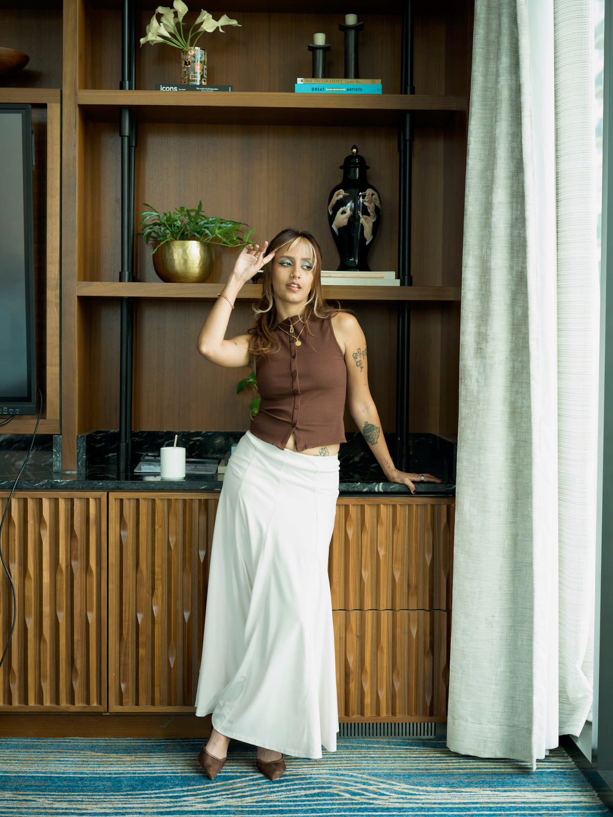 Full-length view of model wearing an ivory flared maxi skirt styled with neutral heels for an elegant, feminine look.