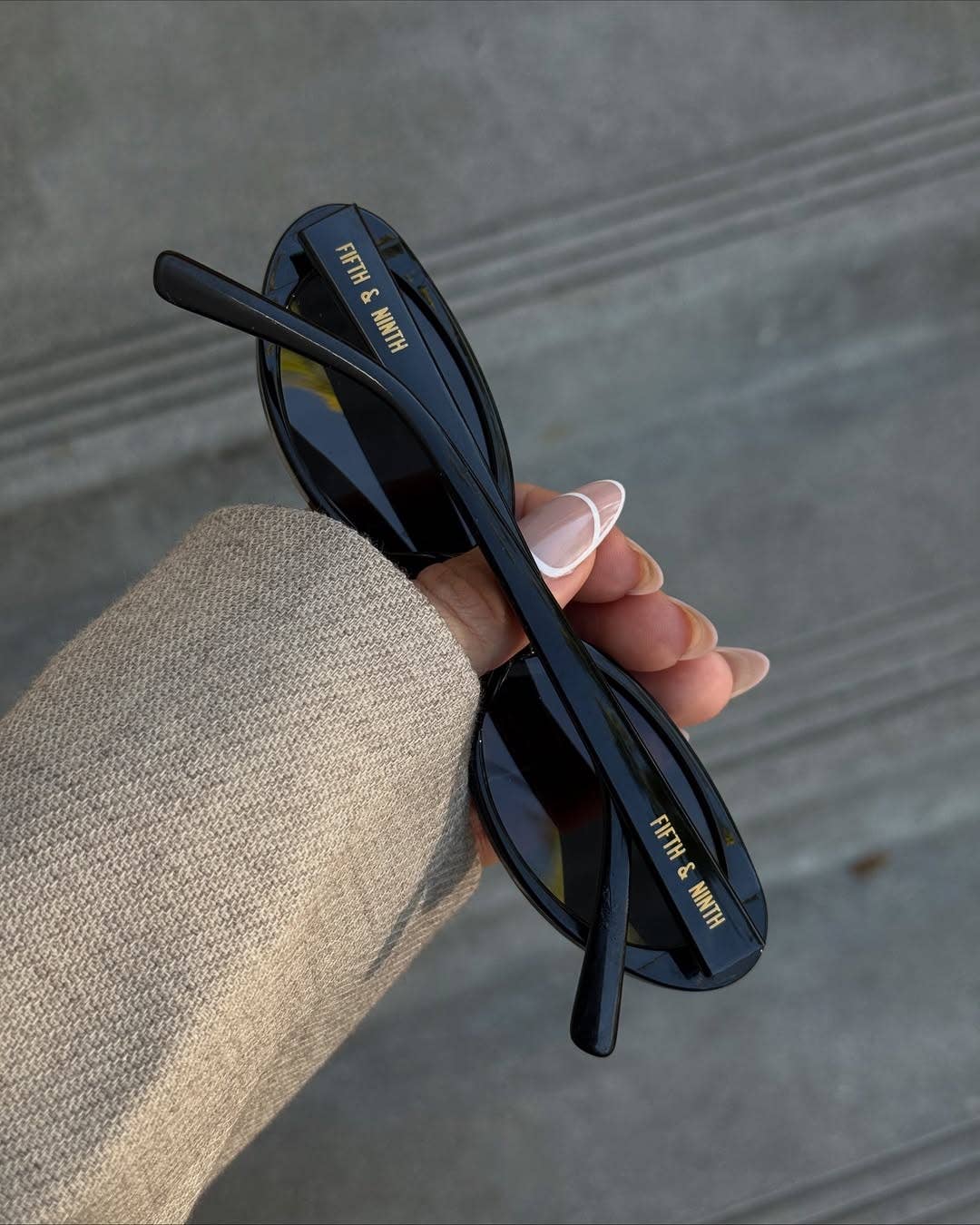 Model holding sunglasses from the back view