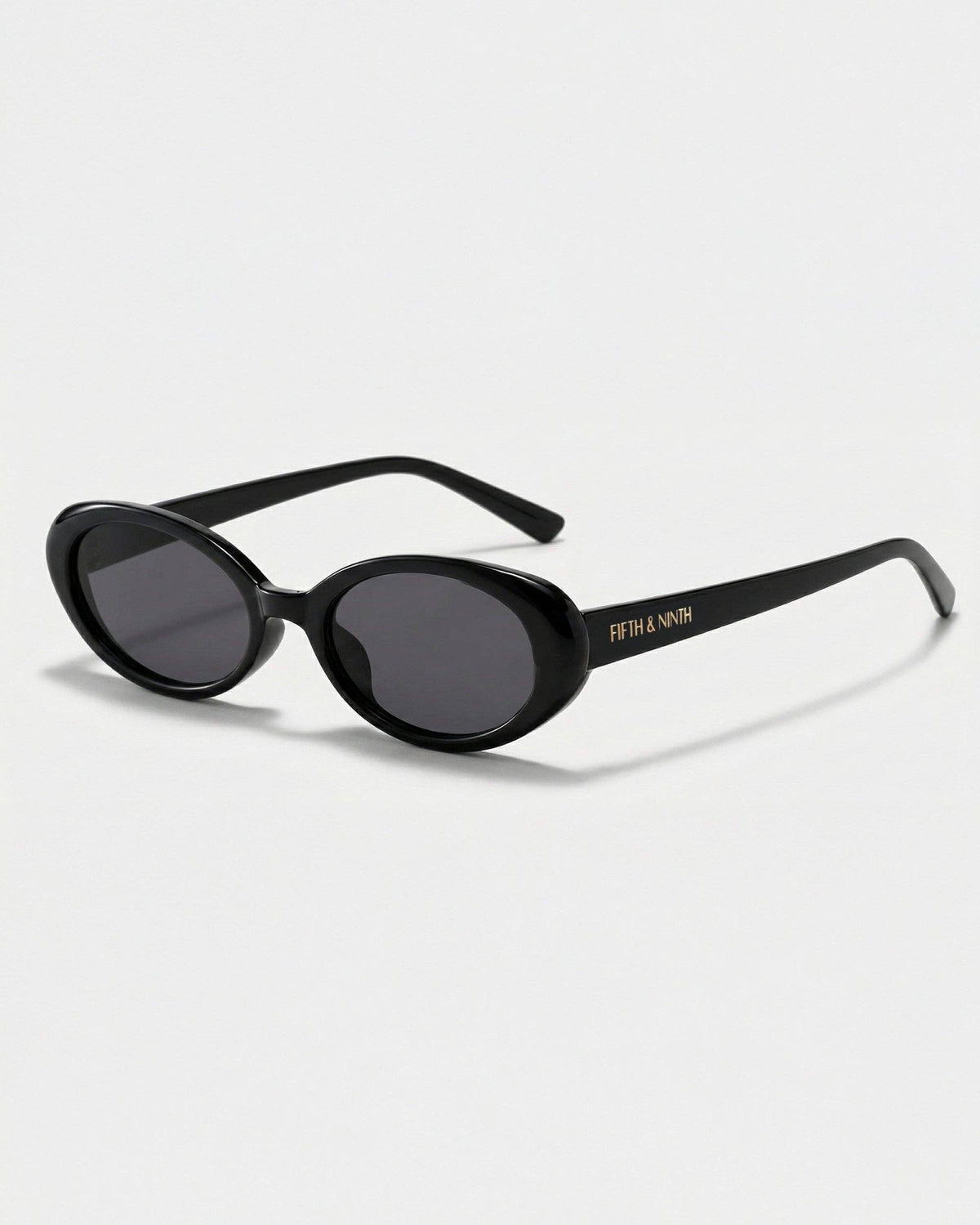 Side profile of black oval polarized sunglasses showcasing the slim temples, polished frame, and petite curved silhouette.