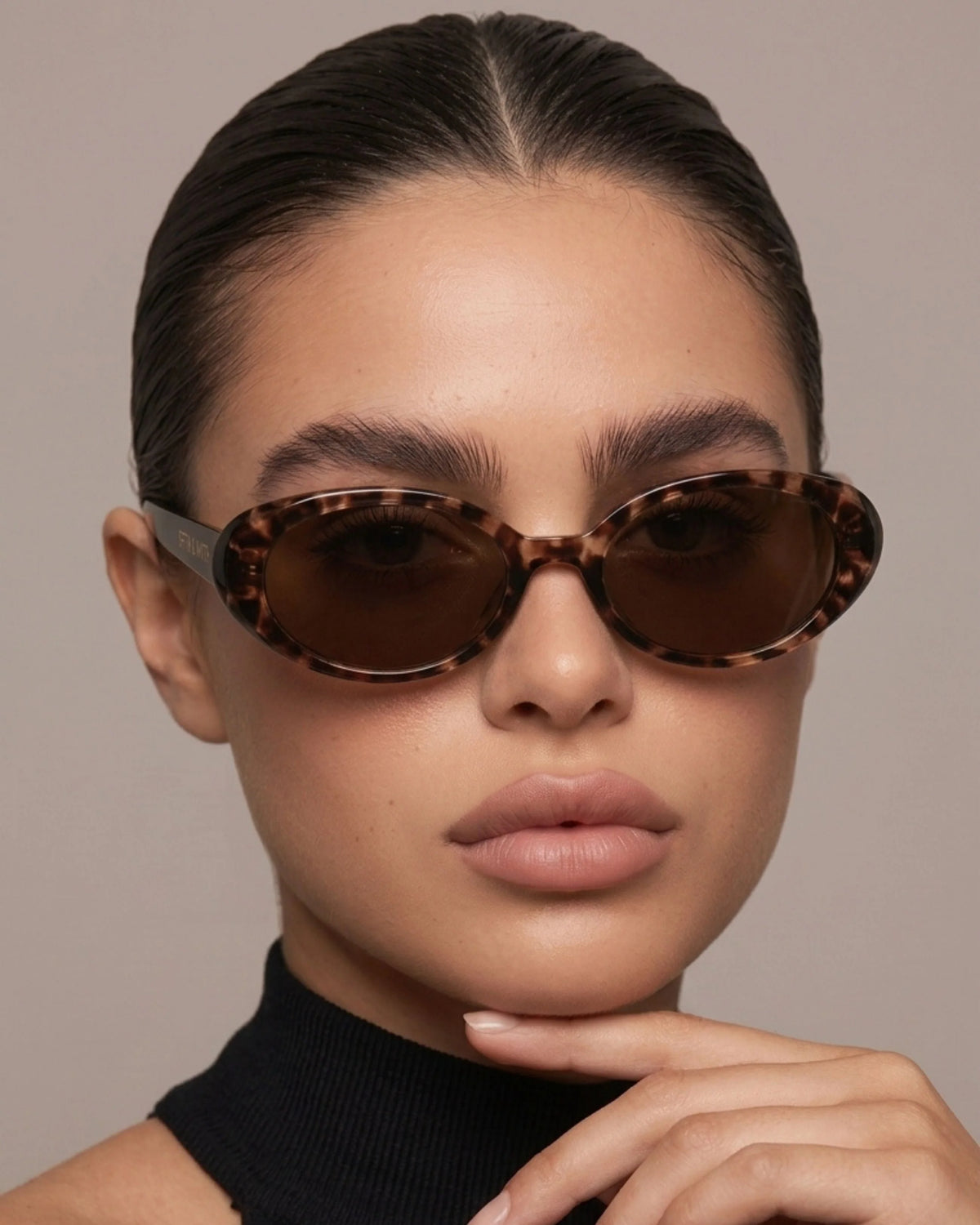 Model wearing tortoiseshell oval polarized sunglasses with brown lenses, showcasing the narrow frame and vintage-inspired silhouette.