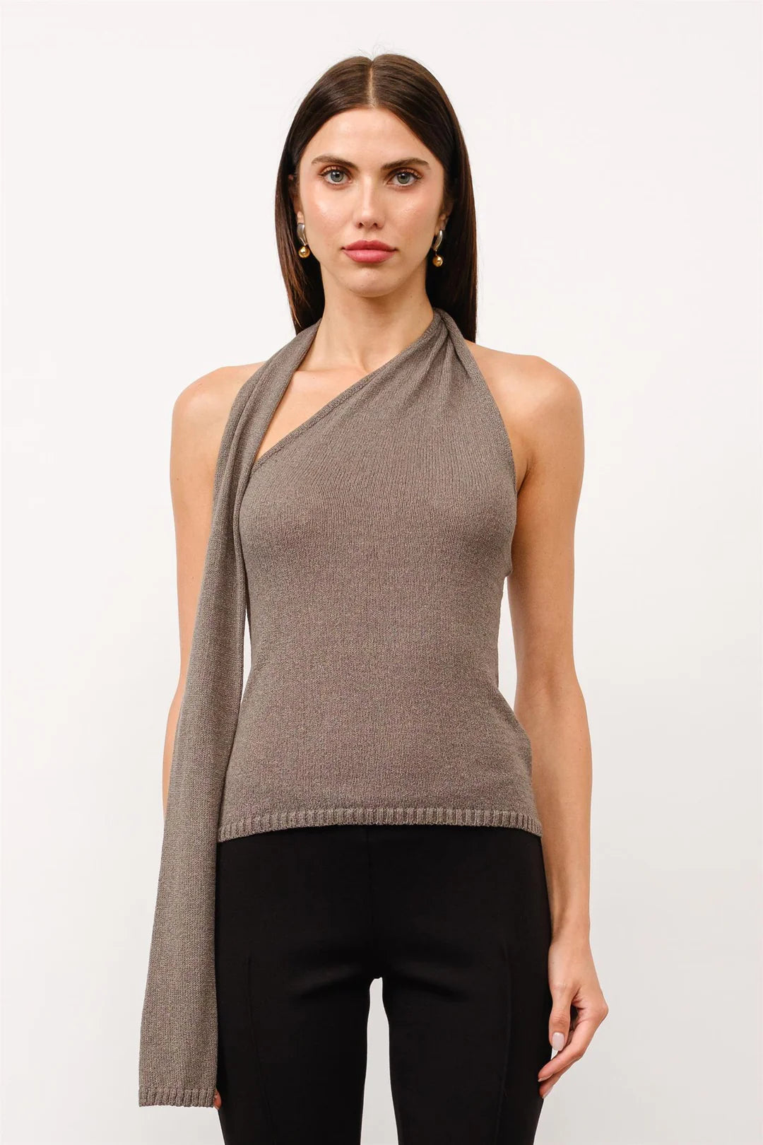 Front view of taupe asymmetrical halter knit top featuring a fitted silhouette, draped scarf detail, and ribbed hemline.