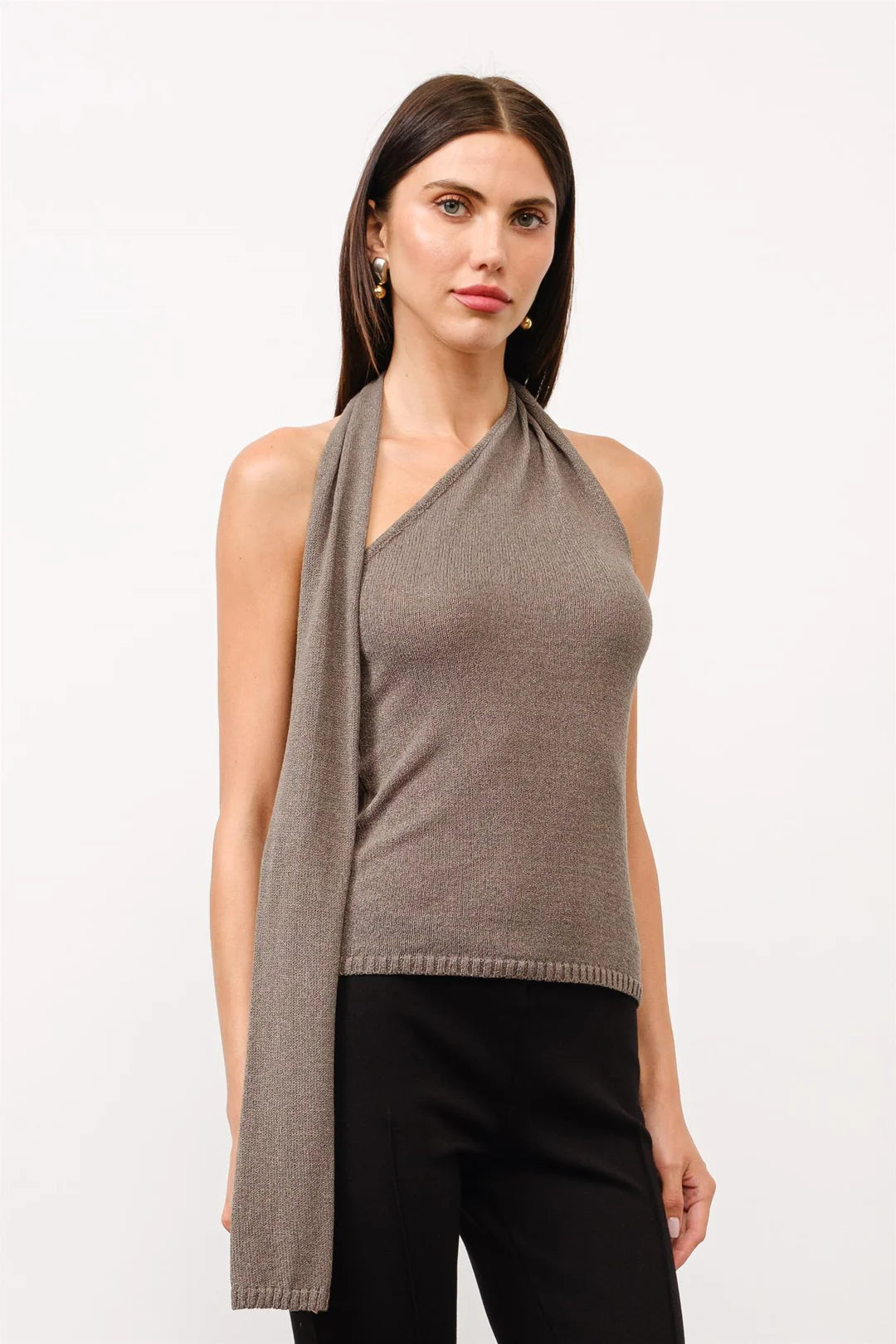 Side view of taupe draped halter knit top featuring an asymmetrical neckline and long scarf detail extending down the front.